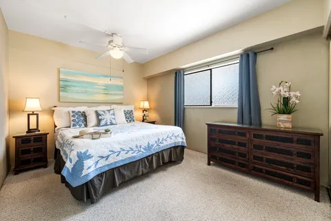 a bedroom with a bed dresser and wooden floor