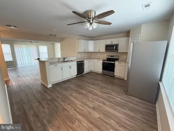 a large kitchen with a white cabinets and stainless steel appliances