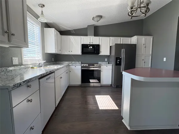 a kitchen with refrigerator cabinets and a sink