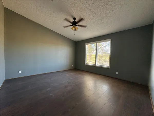 an empty room with a window and a ceiling fan