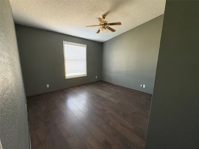 an empty room with a window and a fan