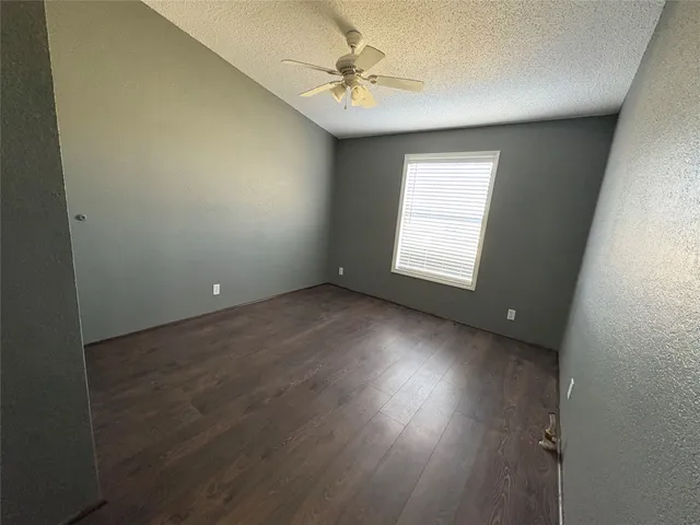an empty room with a window and a fan