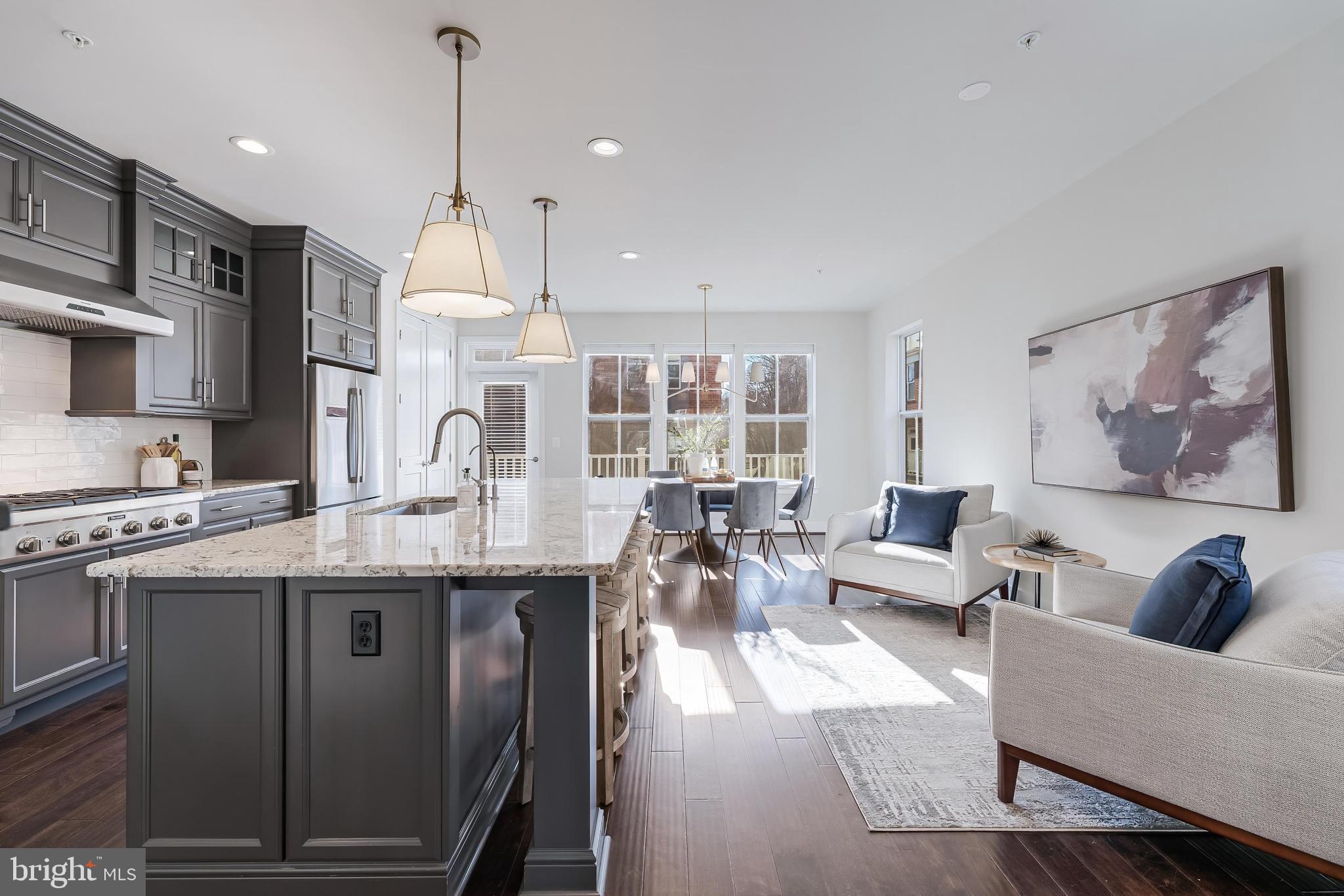 11695 Sunrise Square Place Reston, VA 20191 - Photo 23 of 72 a living room with stainless steel appliances granite countertop couches a fireplace a flat screen tv and kitchen view