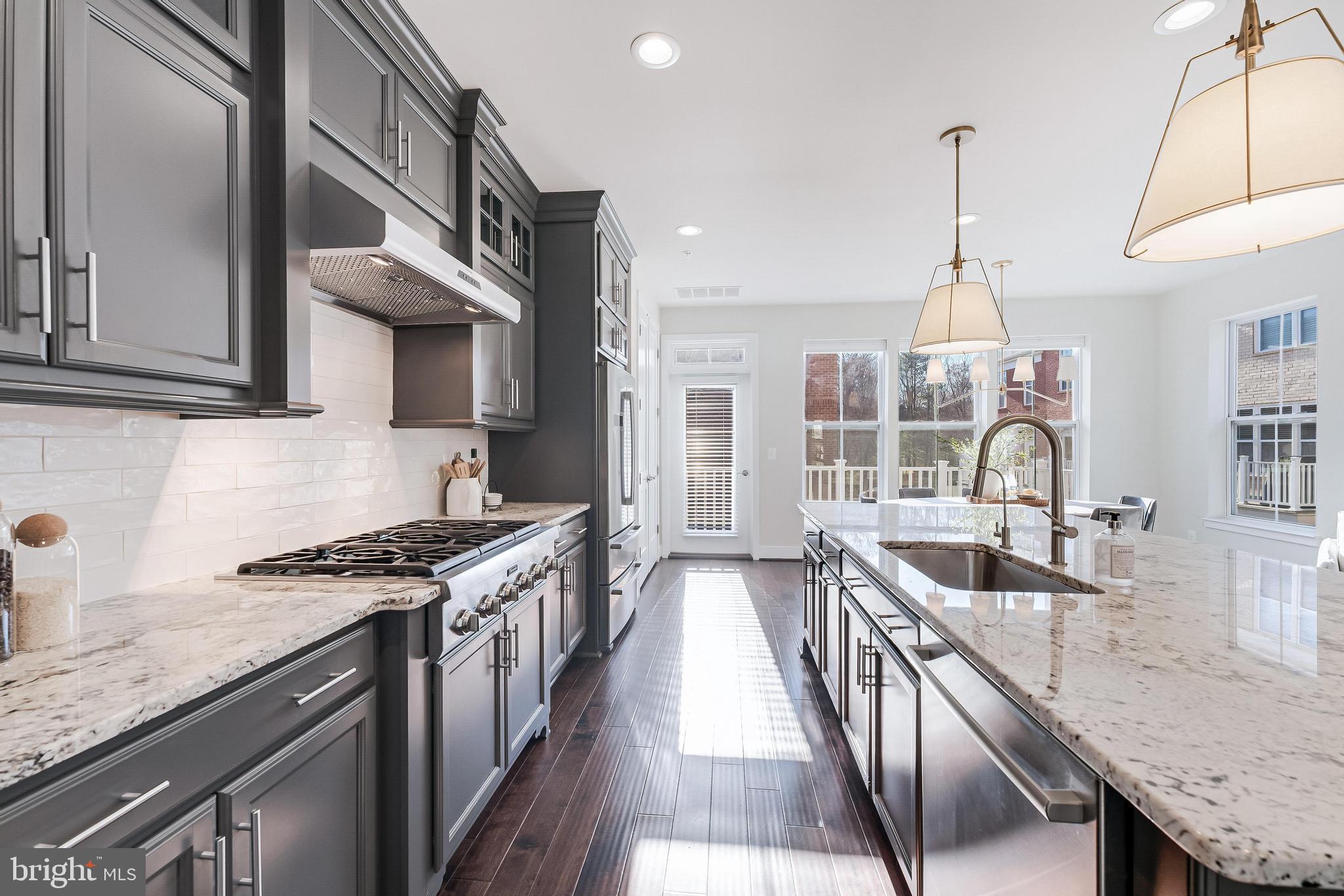 11695 Sunrise Square Place Reston, VA 20191 - Photo 31 of 72 a kitchen with granite countertop a sink a stove and cabinets
