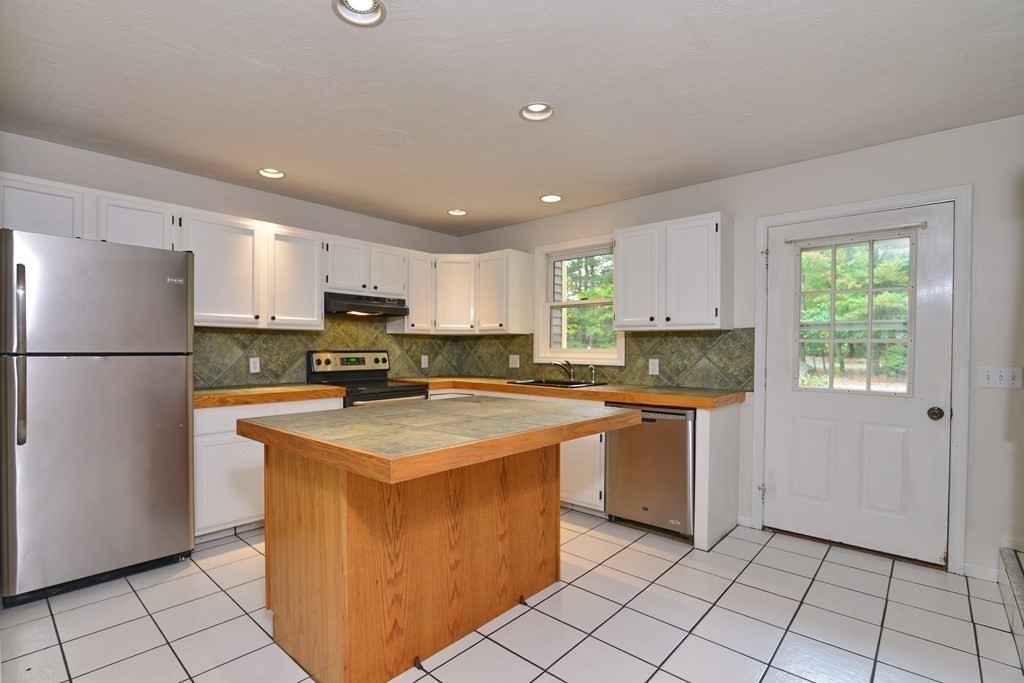 9 May Brook Road, Unit 9 Holland, MA 01521 - Photo 17 of 42 a kitchen with stainless steel appliances granite countertop a refrigerator sink and cabinets