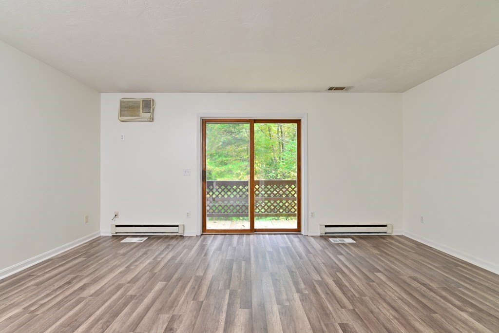 9 May Brook Road, Unit 9 Holland, MA 01521 - Photo 9 of 42 an empty room with wooden floor and windows