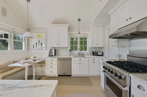 a kitchen with cabinets and stove top oven