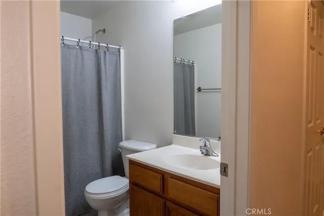 a bathroom with a sink a toilet a mirror and shower