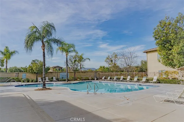 front view of a house with a yard and palm trees