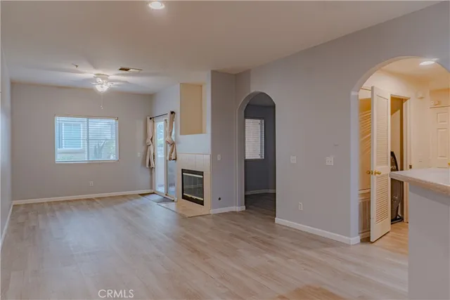 an empty room with wooden floor cabinet and windows