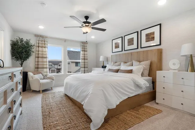 a spacious bedroom with a bed and ceiling fan