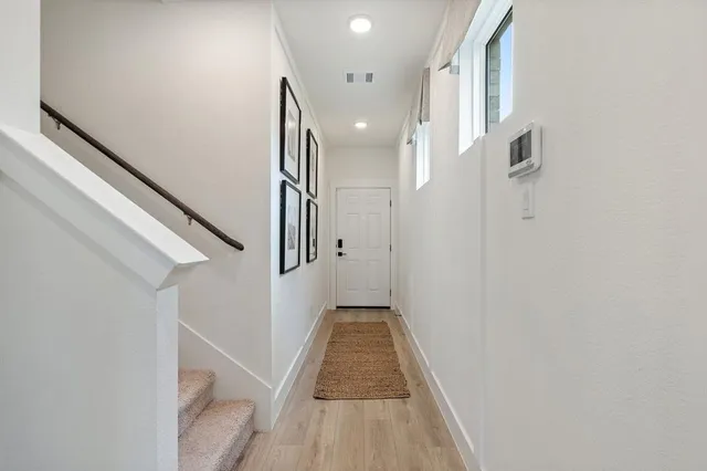 a view of a hallway with wooden floor and staircase