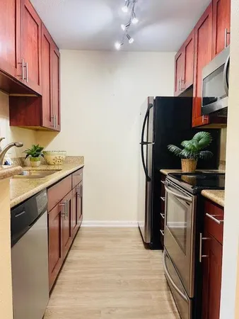 a kitchen with stainless steel appliances granite countertop a stove a sink and a refrigerator
