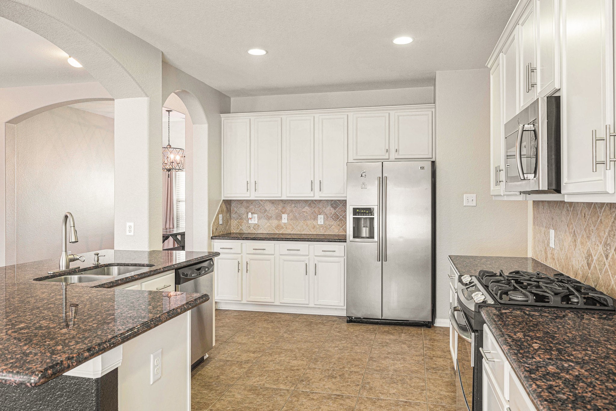 139 North Hawkhurst Circle Magnolia, TX 77354 - Photo 4 of 26 a kitchen with stainless steel appliances granite countertop a sink stove and refrigerator