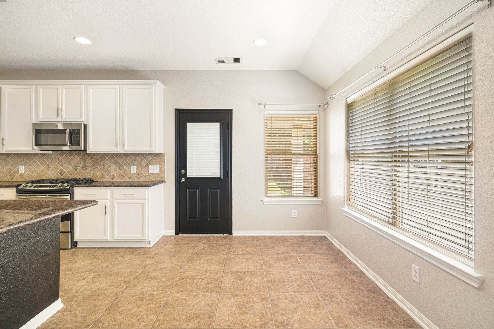 139 North Hawkhurst Circle Magnolia, TX 77354 - Photo 7 of 26 a kitchen with granite countertop a stove a sink and a microwave