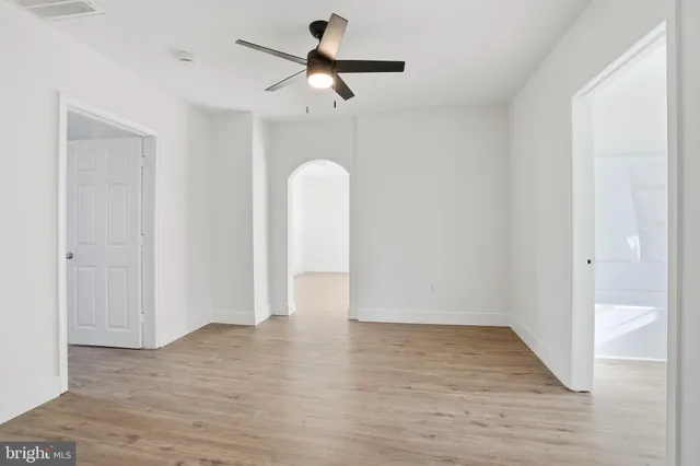 a view of a room with wooden floor and ceiling fan