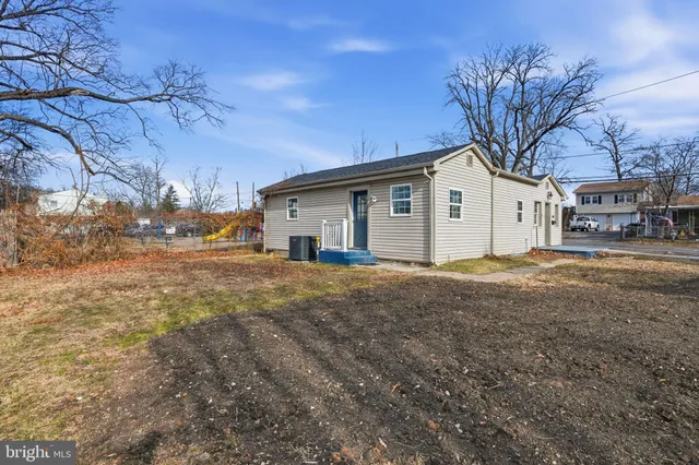 a view of a white house with a large tree in front of it