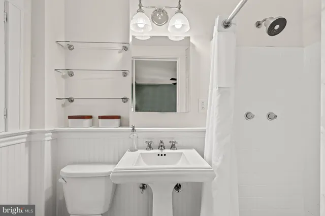 a bathroom with a sink a toilet and mirror