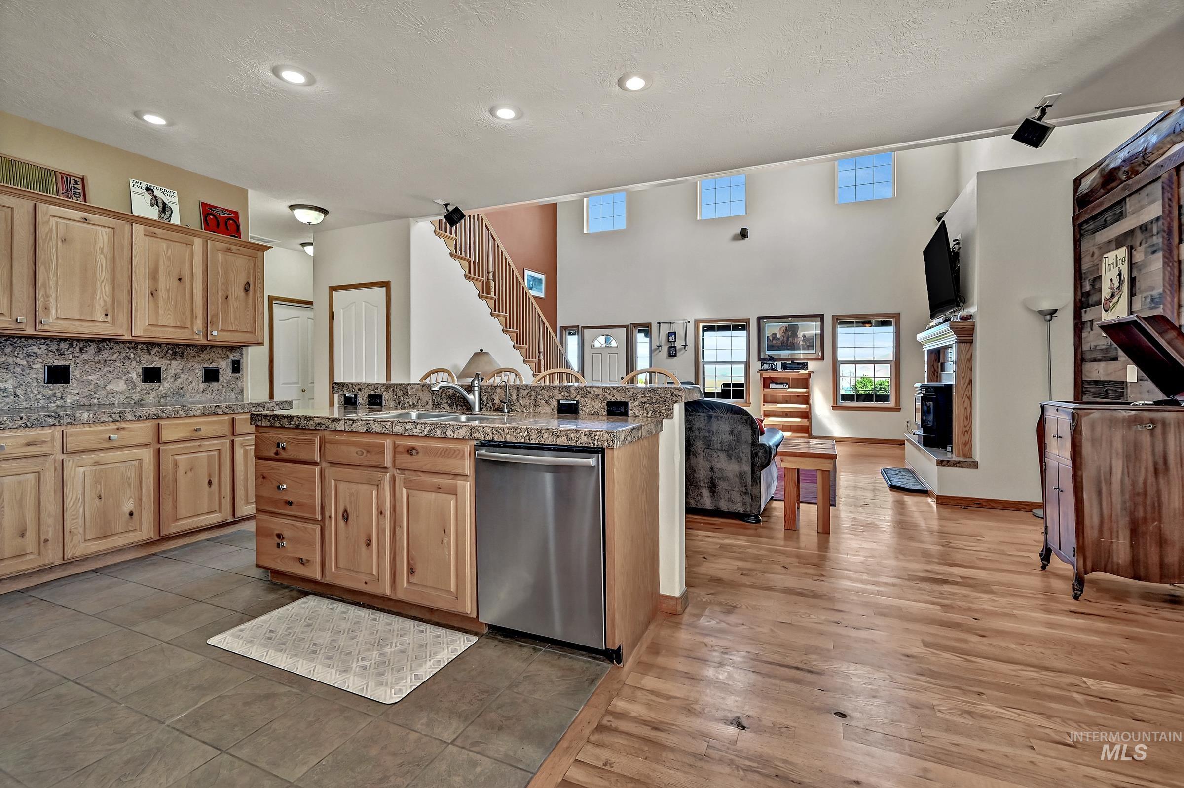 7213 East Columbia Road Boise, ID 83716 - Photo 10 of 47 Open-concept kitchen featuring wood cabinetry, granite countertops, and stainless steel appliances