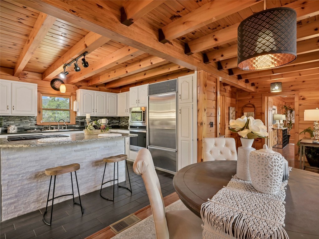 18304 West Reed Park Road Jonestown, TX 78645 - Photo 7 of 24 Exposed wood beams and stone accents enrich this inviting culinary space.