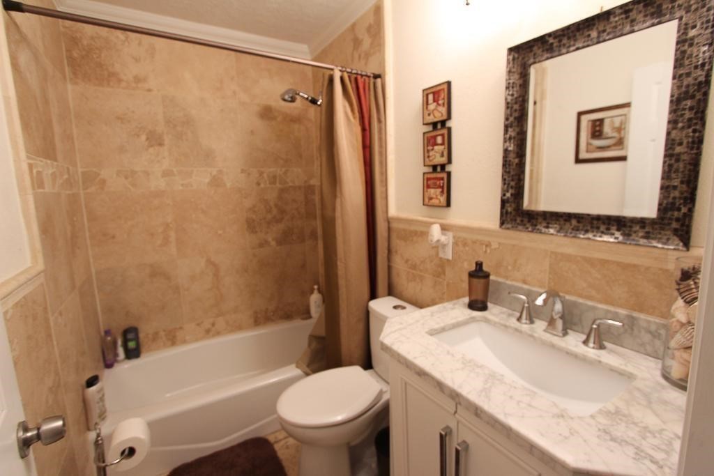 6517 Sivley Street Houston, TX 77055 - Photo 9 of 10 a bathroom with a granite countertop sink toilet and shower