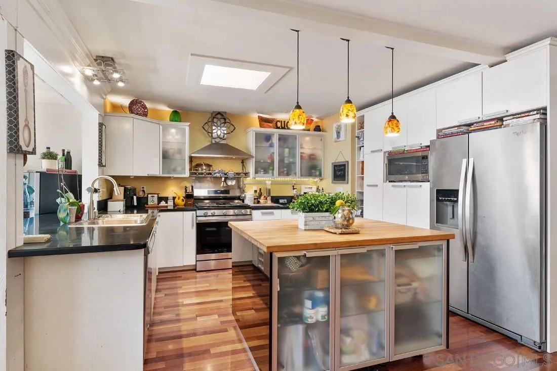 12814 Iola Way Poway, CA 92064 - Photo 12 of 36 a kitchen with kitchen island a counter top space a sink stainless steel appliances and cabinets