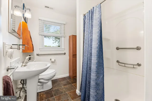 a bathroom with a sink a toilet and a mirror