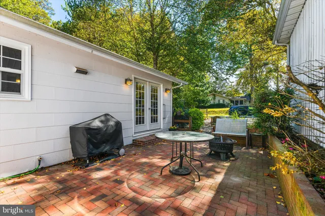 a kitchen with stainless steel appliances kitchen island a table chairs sink and cabinets