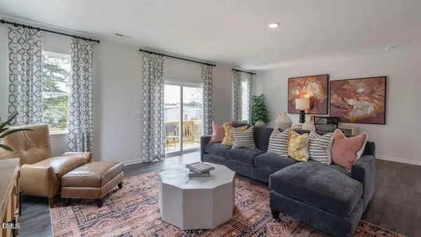 a kitchen with stainless steel appliances granite countertop a stove top oven a sink a dining table and chairs with wooden floor