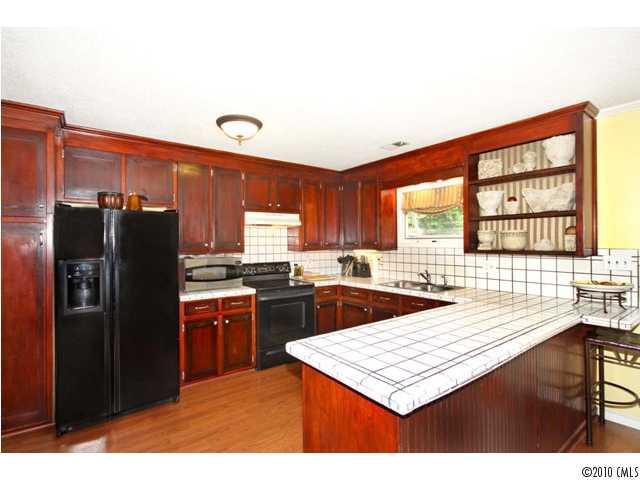 2219 Long Hope Road Monroe, NC 28112 - Photo 11 of 16 a kitchen with stainless steel appliances kitchen island granite countertop a refrigerator and a stove top oven