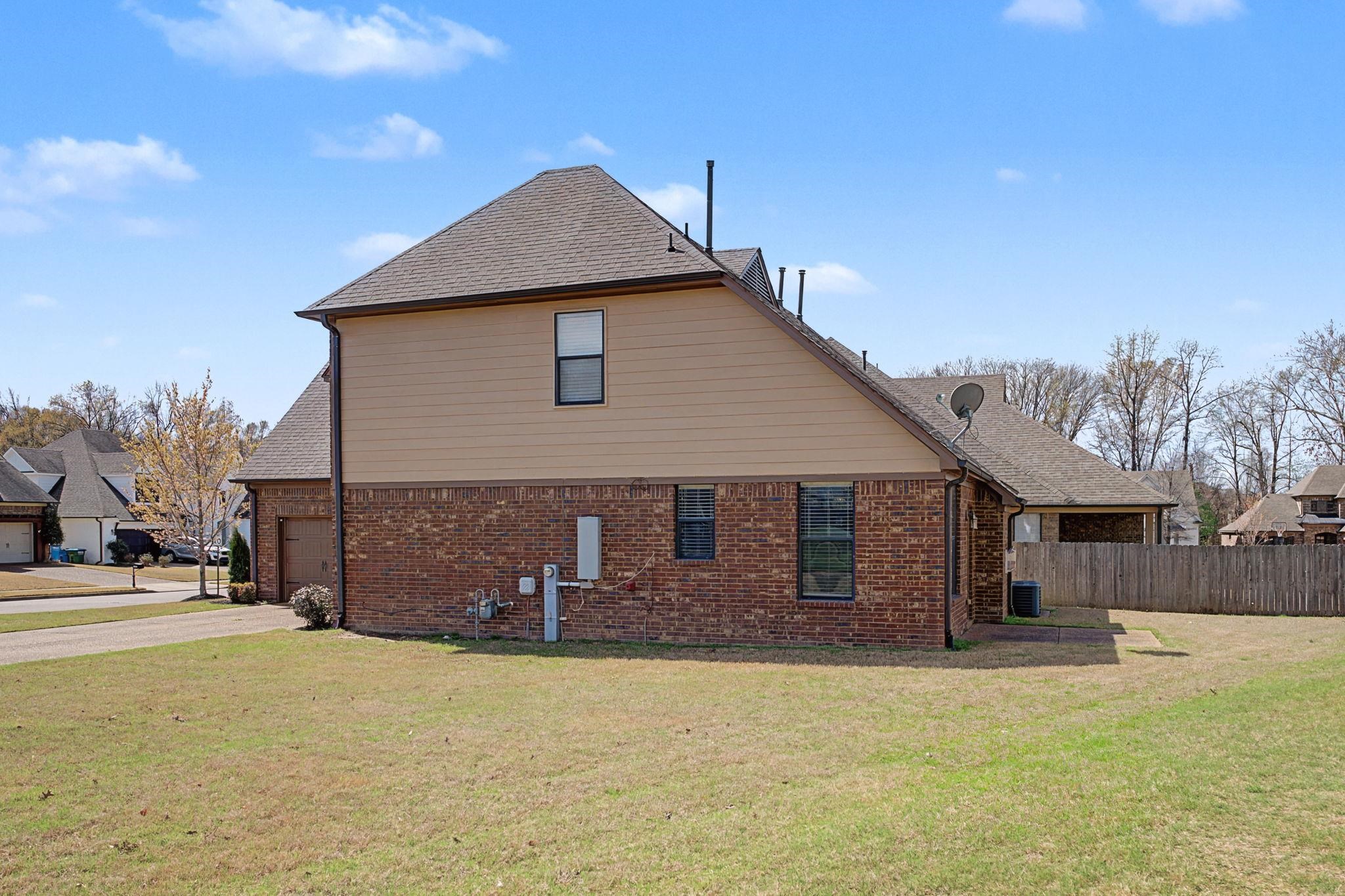 12436 Dusty Field Road Arlington, TN 38002 - Photo 33 of 40 View of home's exterior with brick siding, a shingled roof, and an attached garage
