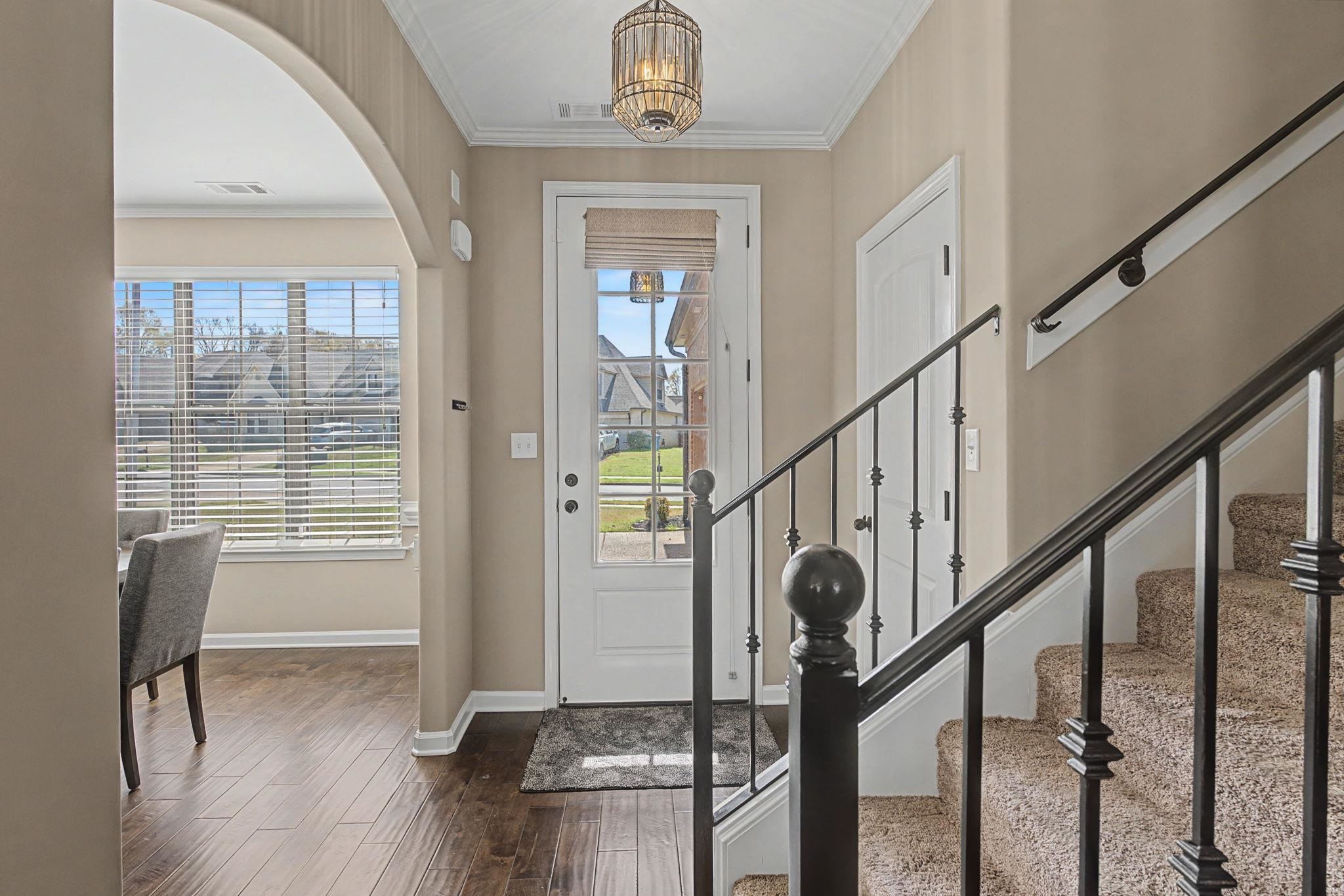 12436 Dusty Field Road Arlington, TN 38002 - Photo 6 of 40 Entrance foyer featuring crown molding, dark wood finished floors, arched walkways, and suspended lighting