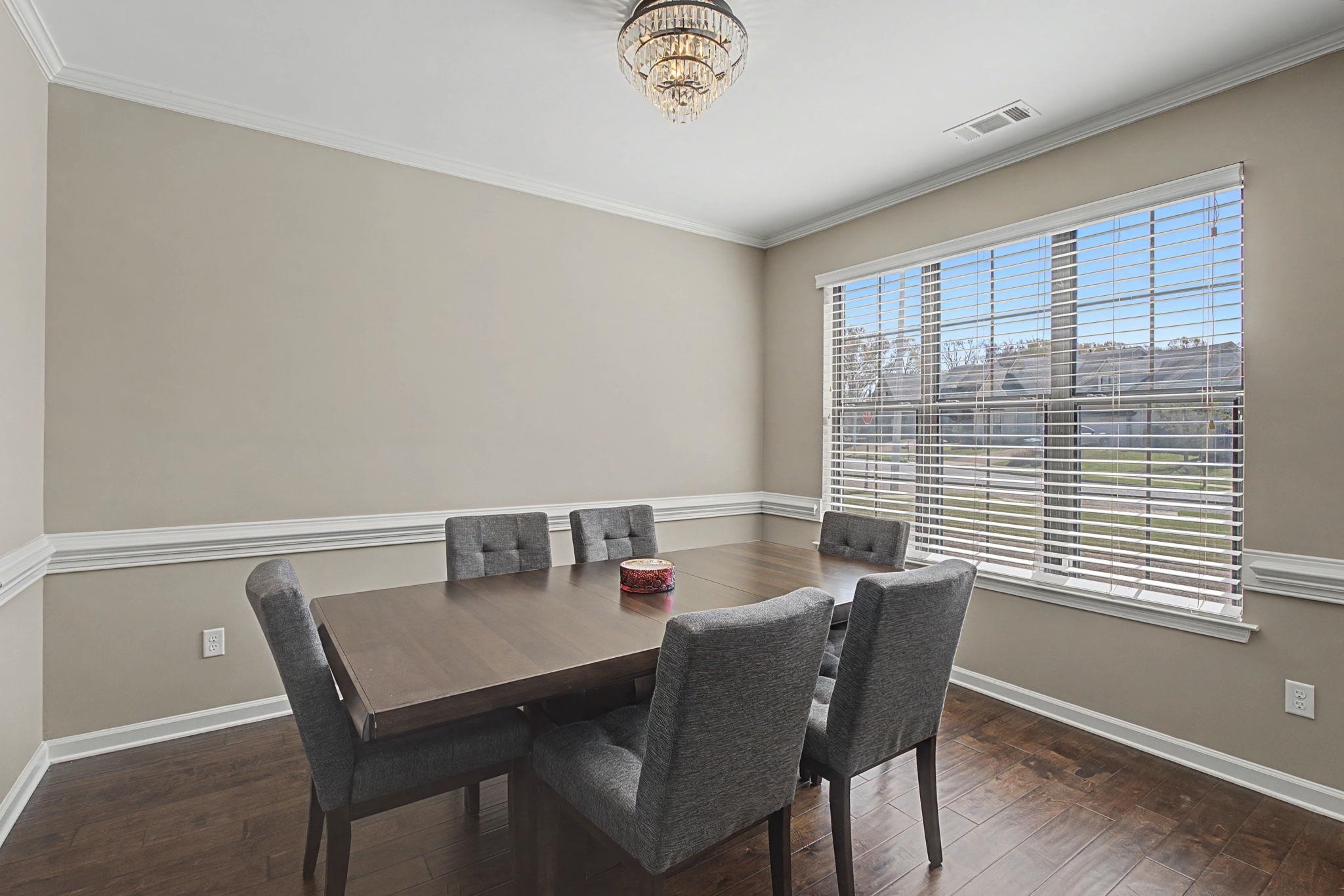 12436 Dusty Field Road Arlington, TN 38002 - Photo 7 of 40 Dining room featuring dark wood-style flooring, crown molding, and suspended lighting