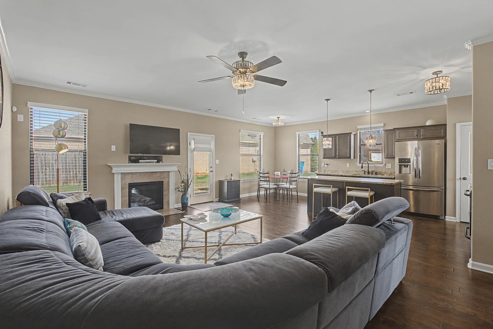 12436 Dusty Field Road Arlington, TN 38002 - Photo 9 of 40 Living area featuring ornamental molding, a ceiling fan, dark wood-style floors, and a fireplace
