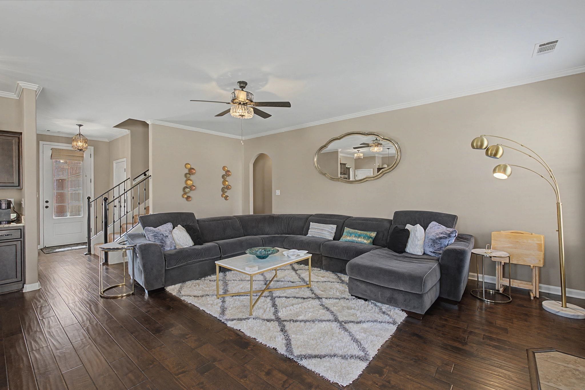 12436 Dusty Field Road Arlington, TN 38002 - Photo 10 of 40 Living room with dark wood finished floors, crown molding, a ceiling fan, and arched walkways