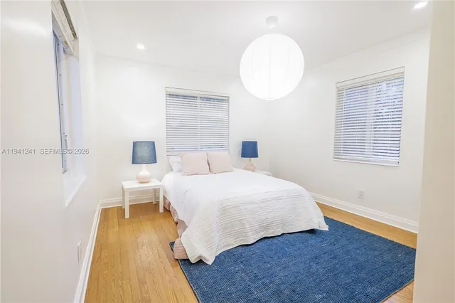 a bedroom with a bed and a lamp on dresser
