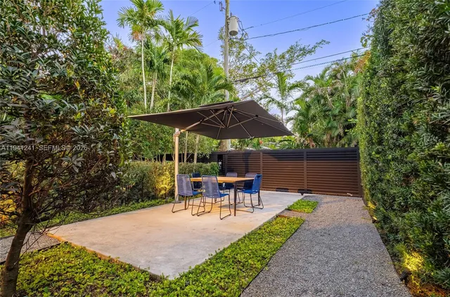 a view of backyard with table and chairs under an umbrella