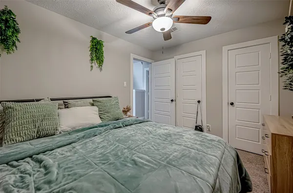 a bedroom with a large bed and a chandelier