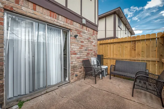 a backyard of a house with barbeque oven table and chairs