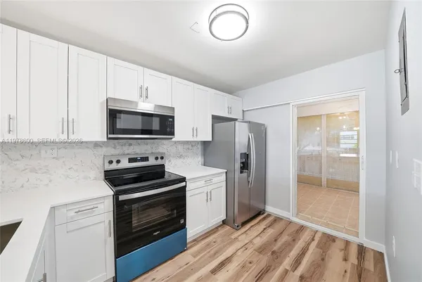 a view of a livingroom with wooden floor and a ceiling fan