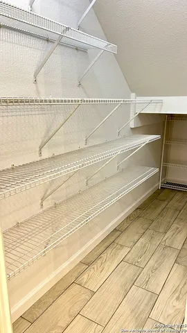 a kitchen with stainless steel appliances granite countertop a sink and white cabinets with wooden floor