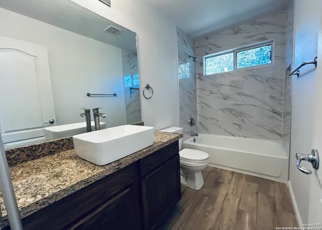 a bathroom with a toilet sink and mirror