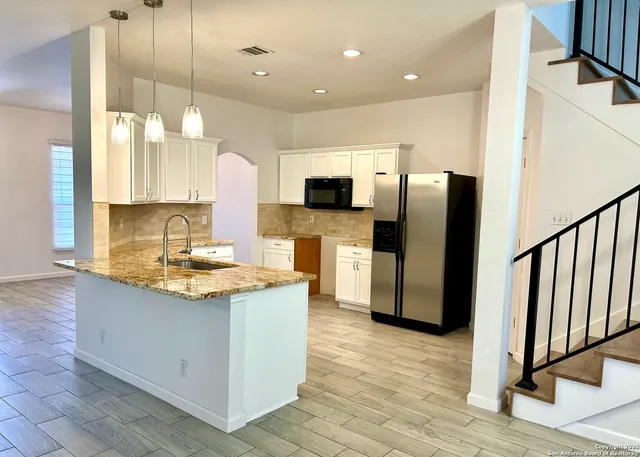 a kitchen with stainless steel appliances granite countertop a sink stove and refrigerator