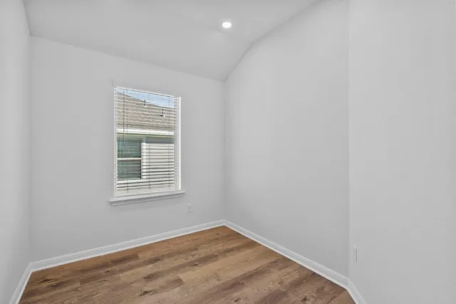 an empty room with wooden floor and a window
