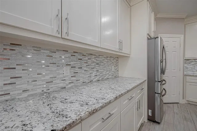 a kitchen with a granite countertop sink and cabinets