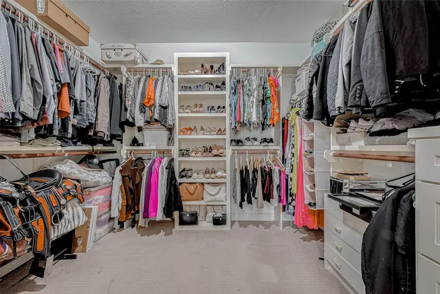 a view of walk in closet with clothes