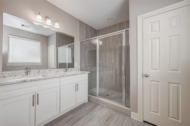 a bathroom with a shower sink and mirror