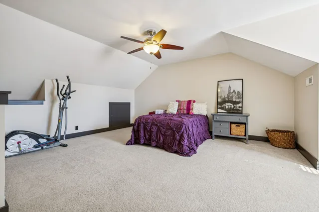 a bedroom with a bed and a ceiling fan