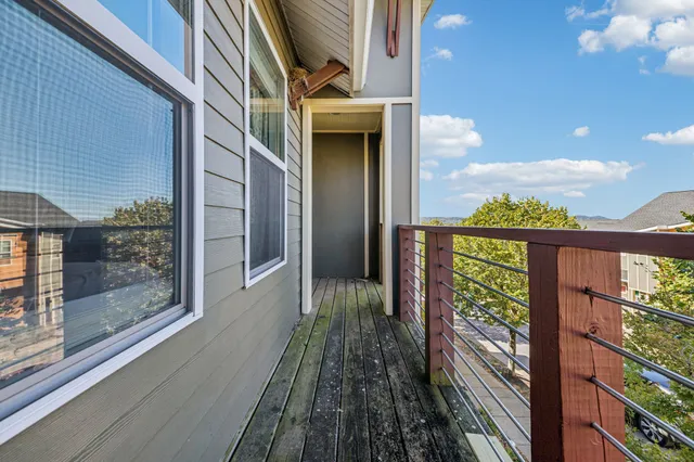 a view of a balcony with wooden floor and chairs