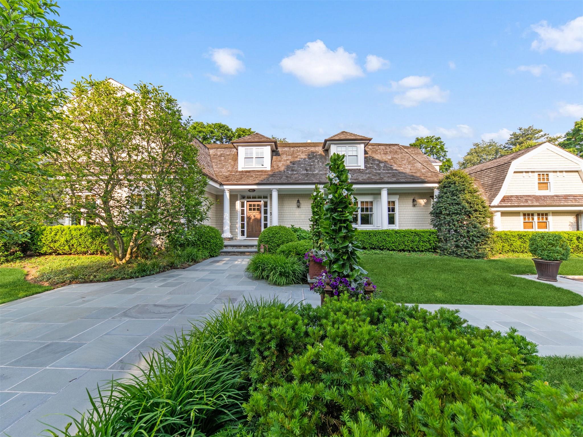 a view of a house with a yard and potted plants